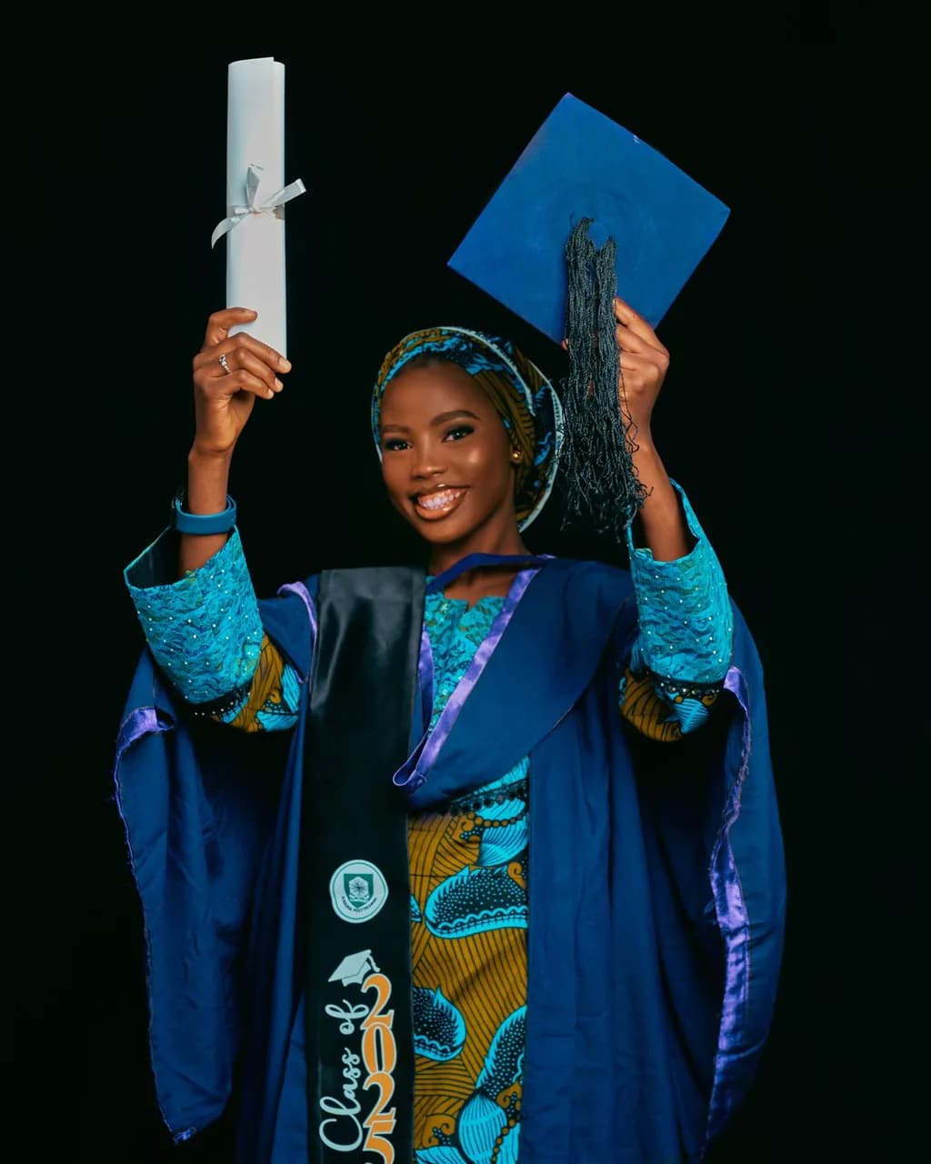 Jeune diplômée brandissant son diplôme et sa toque